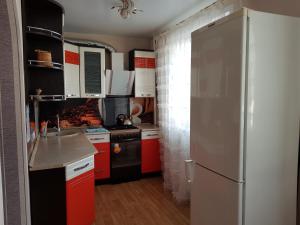 ウシンスクにあるАппартаменты на Ленина, 15のキッチン(赤いキャビネット、冷蔵庫付)