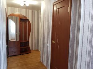 ウシンスクにあるАппартаменты на Ленина, 15の鏡と茶色のキャビネット付きの廊下