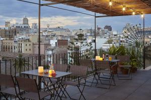 patio ze stołami i krzesłami na balkonie w obiekcie Casa Camper Barcelona w Barcelonie