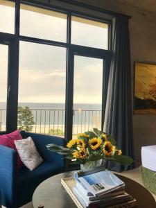 una sala de estar con una mesa con un jarrón de flores en Sea Forest Homestay, en Suao