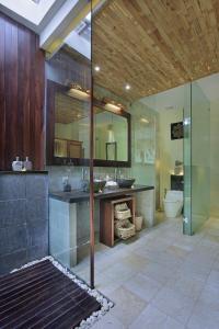 a bathroom with a sink, toilet, and bathtub at The Kayon Resort in Ubud