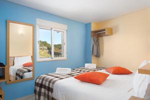1 dormitorio con paredes azules y 1 cama con almohadas de color naranja en Casas de Sequeiros, en Sequeiros