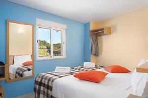 um quarto com paredes azuis e uma cama com almofadas laranja em Casas de Sequeiros em Sequeiros