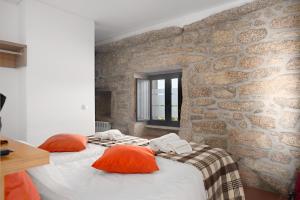 um quarto com 2 camas e uma parede de pedra em Casas de Sequeiros em Sequeiros