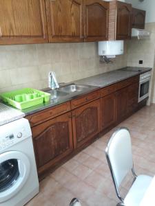 a kitchen with a sink and a washing machine at Apartamento 300 metros do SANTUÁRIO DE FÁTIMA T4 in Fátima