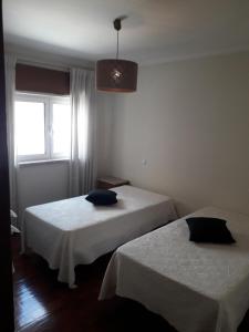 2 camas en una habitación con ventana en Apartamento 300 metros do SANTUÁRIO DE FÁTIMA T4, en Fátima