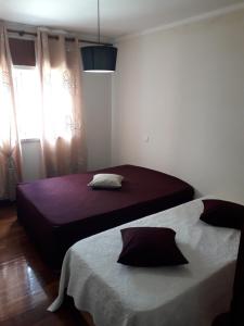 1 dormitorio con 2 camas y ventana en Apartamento 300 metros do SANTUÁRIO DE FÁTIMA T4, en Fátima