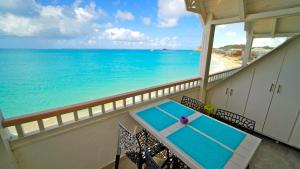 a balcony with a table and a view of the ocean at Grand Case Beach in Grand Case