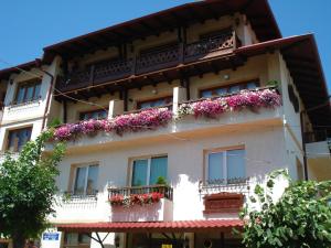 um edifício de apartamentos com flores nas varandas em Pri Ani Guest House em Bansko