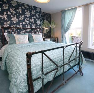 - une chambre avec un lit et un papier peint floral dans l'établissement The Mainstay Luxury Boutique Rooms with Private Parking, à Whitby