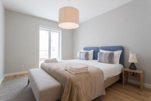 a white bedroom with a large bed and a window at FLH Rato Spacious Apartment in Lisbon