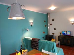 a room with a blue wall with a table and a light at Quinta Laranja - Turismo Rural - in Alvorninha