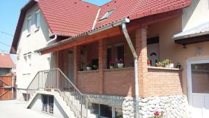 a house with a red roof with potted plants at Pál utcai Apartman Miskolc in Miskolc