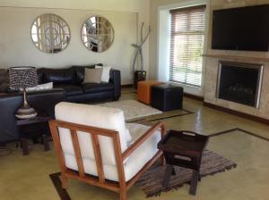 Una sala de estar con un sofá y una chimenea. en Twin Rivers Villa, en Plettenberg Bay