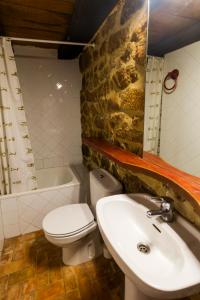 a bathroom with a sink and a toilet and a tub at Casas Canduela in Canduela