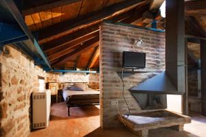 a living room with a fireplace and a bedroom at Casas Canduela in Canduela