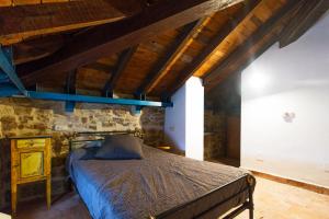 a bedroom with a bed in a room with wooden ceilings at Casas Canduela in Canduela