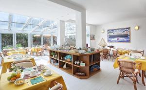 uma sala de jantar com mesas, cadeiras e janelas em Hotel Yacht Club em Marciana Marina