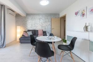ein Wohnzimmer mit Tisch und Stühlen und einer Couch in der Unterkunft Apartments Villa Tre Marie in Rovinj