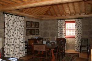 ein Esszimmer mit einem Tisch und einem Fenster in der Unterkunft Quinta da Fonte Arcada in Paço de Sousa