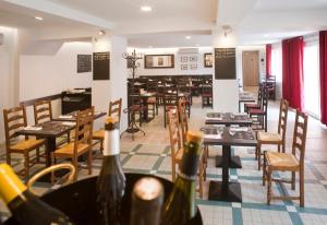 a restaurant with tables and chairs and wine bottles at Comptoir et Dépendances in Frontonas