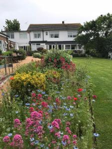 a garden with colorful flowers in front of a house at The Coast Yard B & B and Garden Chalets in Chichester