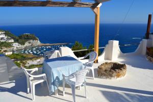 eine Terrasse mit einem Tisch, Stühlen und Meerblick in der Unterkunft Maridea - Vela in Ponza