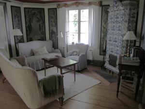 un soggiorno con divano, sedie e tavolo di Uddens Bed & Breakfast a Öregrund