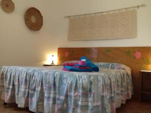 Un dormitorio con una cama con una manta azul. en Canne Al Vento, en Teulada