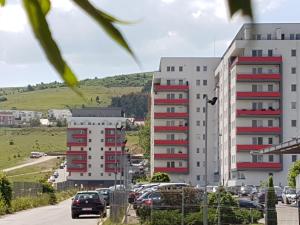 two tall buildings with cars parked in a parking lot at Viv Apartments 65 in Floreşti