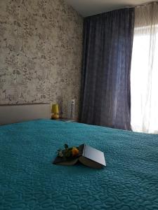 a book laying on a bed in a bedroom at Viv Apartments 65 in Floreşti