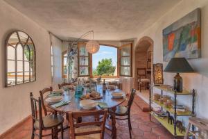 een eetkamer met een houten tafel en stoelen bij Casa Bernardino by VacaVilla in Campiglia Marittima