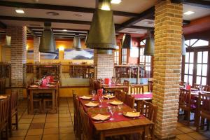 un restaurante con mesas y sillas en una habitación en Hotel Palacio de Cristal, en Burela de Cabo