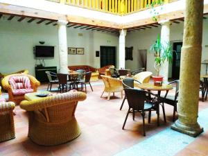a living room with tables and chairs and a lobby at Hotel Palacio Buenavista in Belmonte