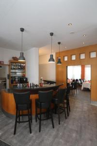 a bar in a restaurant with chairs and a counter at Asgard Hotel in Worms