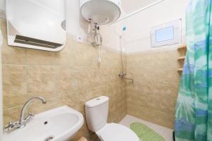 a bathroom with a toilet and a sink and a shower at Мини Отель Милый in Sanzhiyka