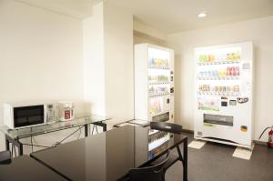 a dining room with a table and a refrigerator at Hotel Shin-Imamiya in Osaka
