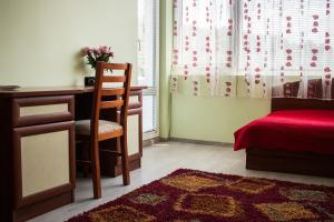 ein Schlafzimmer mit einem Schreibtisch und einem Stuhl neben einem Fenster in der Unterkunft Апарт Пееви in Gabrowo