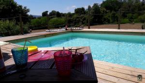 three glasses sitting on a table next to a swimming pool at B&B il Fienile di Scarperia in Scarperia