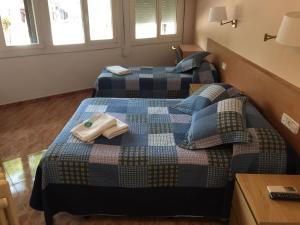 a bedroom with two beds with towels on them at Hostal Rio De Castro in Barcelona