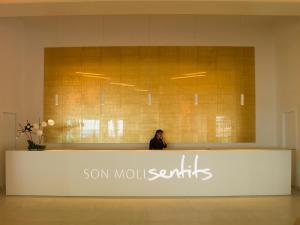 a woman standing behind a counter in a lobby at Son Moll Sentits Hotel & Spa in Cala Ratjada