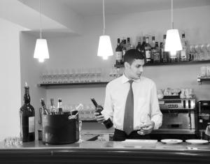 Een man in een stropdas met een fles wijn. bij Comptoir et Dépendances in Frontonas