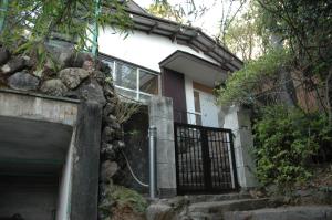 ein Haus mit einem Tor und einer Treppe davor in der Unterkunft 熱海貸切り別荘網代の家 in Ajiro