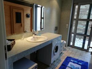 uma casa de banho com um lavatório e uma máquina de lavar roupa em Dimitra em Rafina