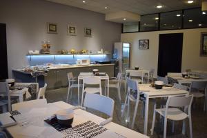 a restaurant with tables, chairs, and tables in it at Hotel Baffo Rosso in Alba Adriatica