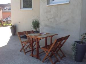 Une table et des chaises en bois sont disponibles sur la terrasse. dans l'établissement Kleine Oase, à Rust