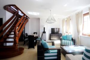 un soggiorno con una scala, un tavolo e delle sedie di Seaside Apartamenty Puck a Puck