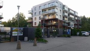 um grande edifício com uma cerca em frente em Apartament Morskie Polanki em Kolobrzeg