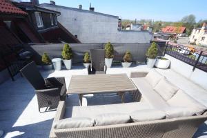 un patio con tavolo e sedie sul tetto di Seaside Apartamenty Puck a Puck