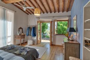 a bedroom with a bed and a table and windows at Casa Bernardino by VacaVilla in Campiglia Marittima